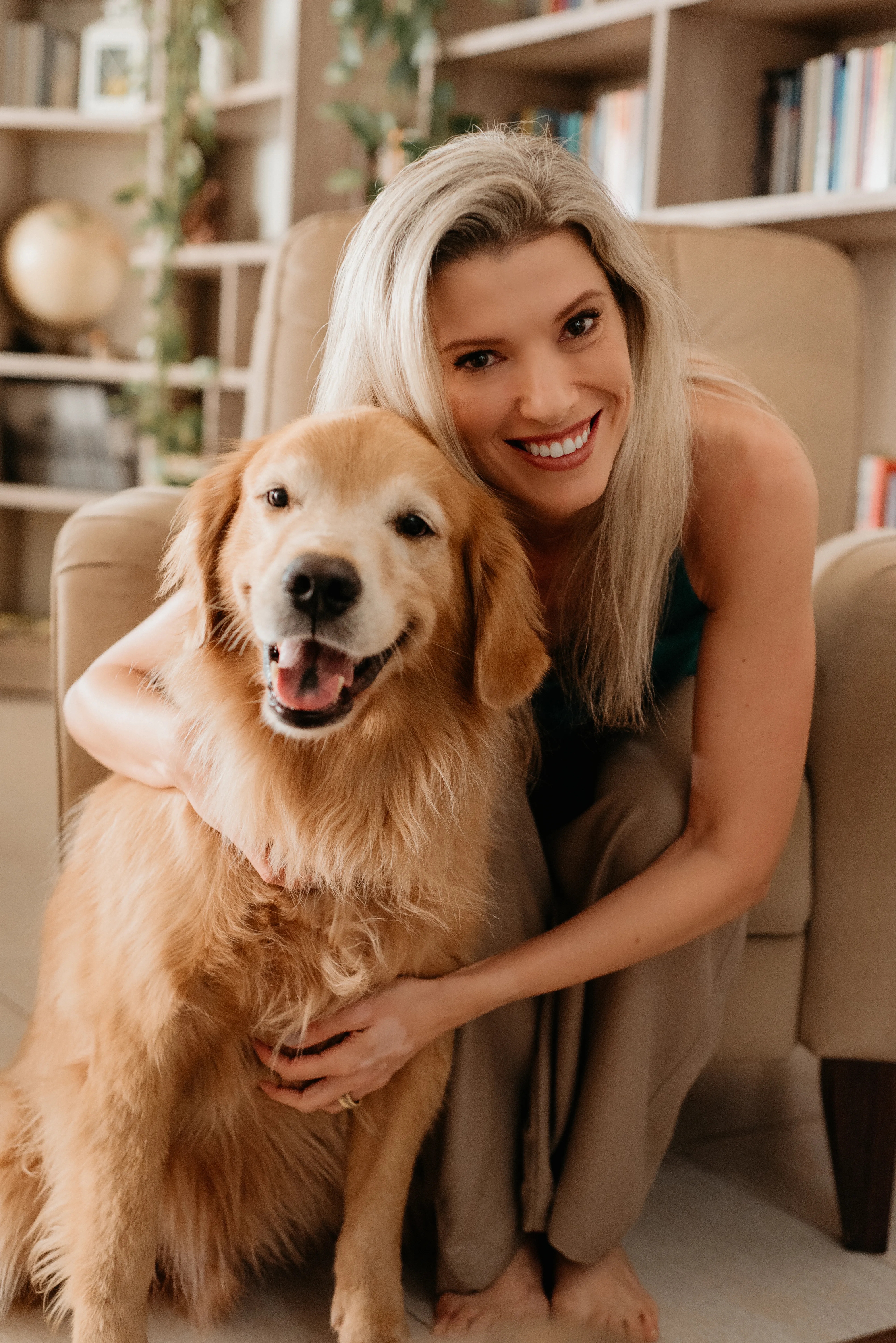 Carol Kirsten sorrindo com seu cachorro golden retriever