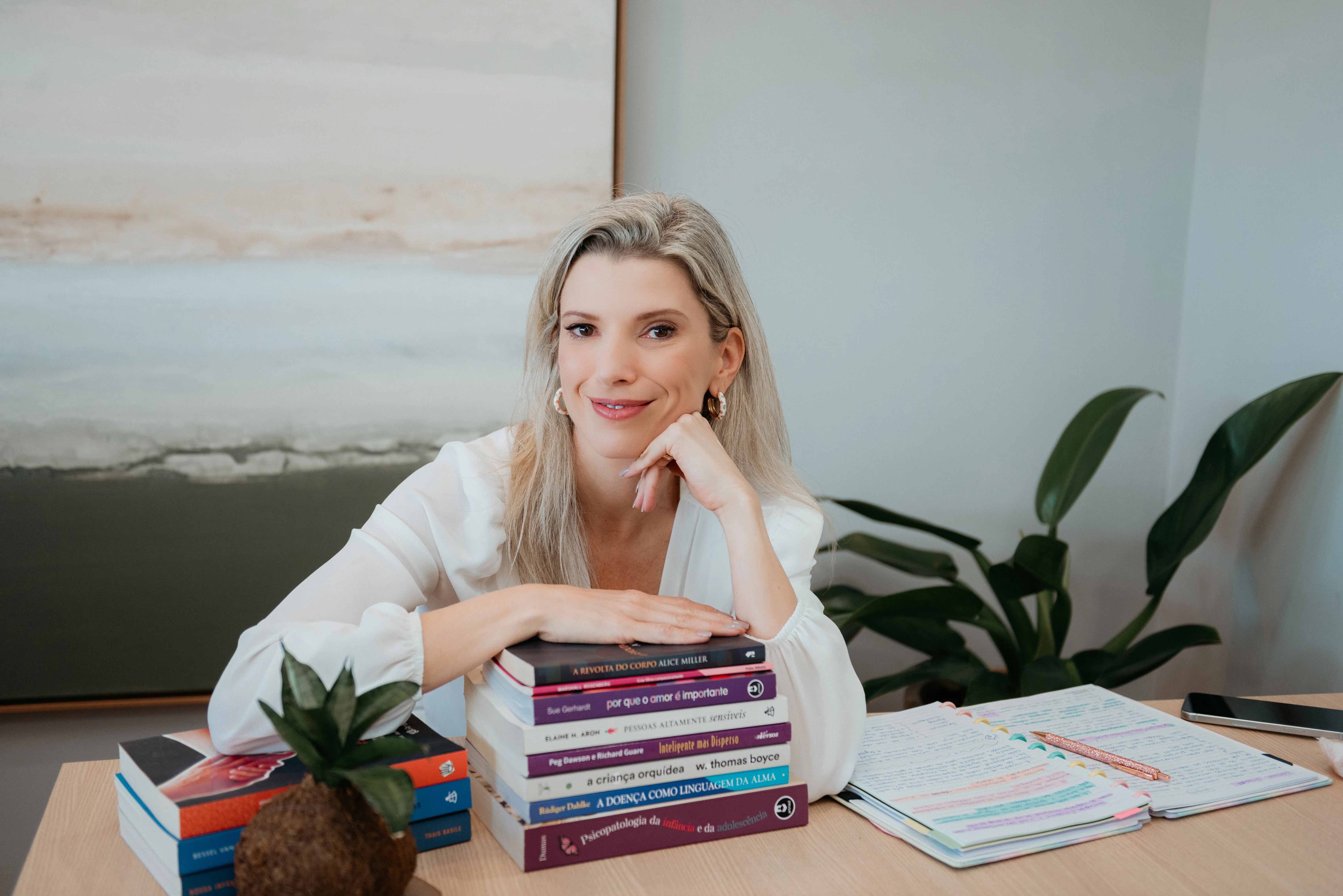 Carol Kirsten apoiada sobre seus livros de psicologia