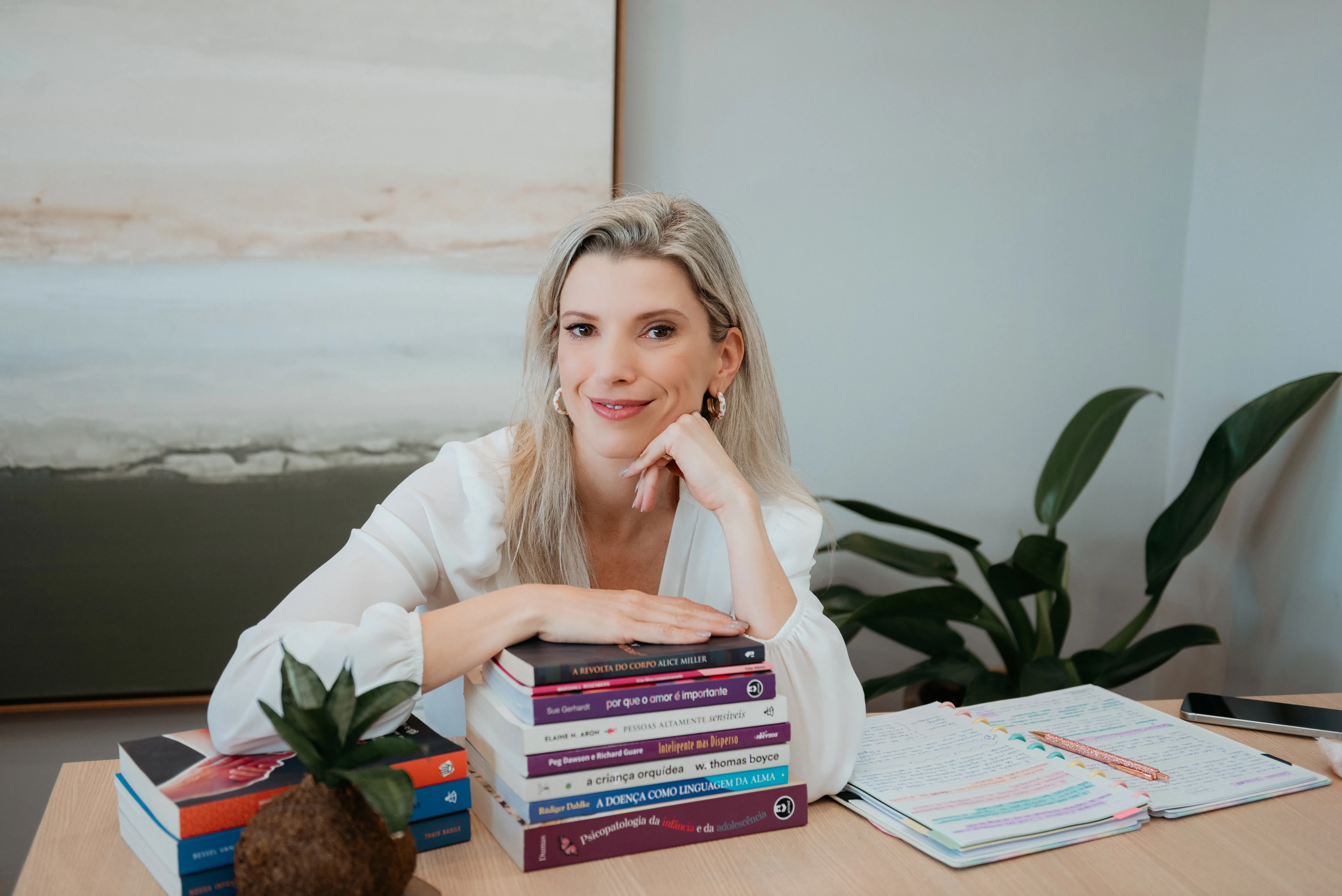Carol Kirsten apoiada sobre seus livros de psicologia